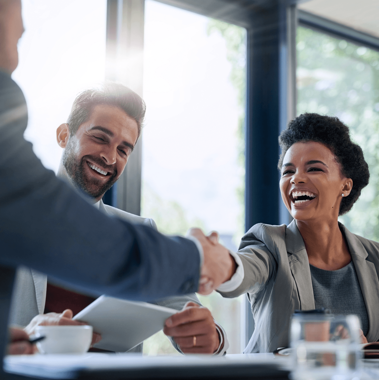 Diverse, professional employees shaking hands in agreement, welcome or greeting.